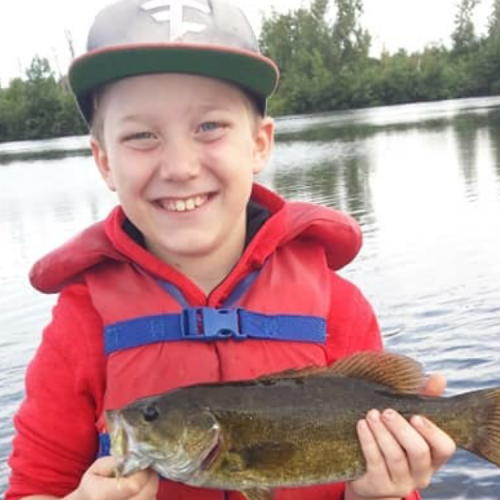 Boy holding fish caught from Woodruff pond